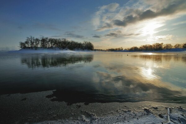 Fluss und Insel mit Bäumen am Himmelshintergrund