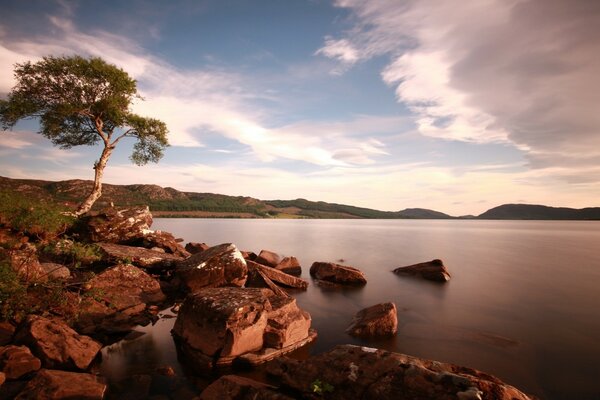 A costa rochosa de um lago calmo