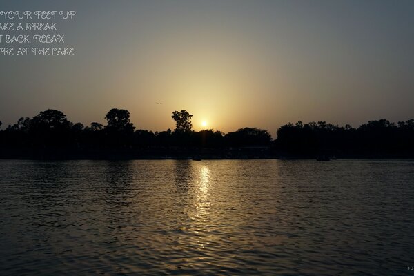 Foto del sole al tramonto sul lago al crepuscolo
