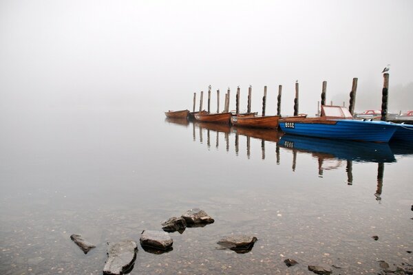 Bateaux sur le quai dans le brouillard