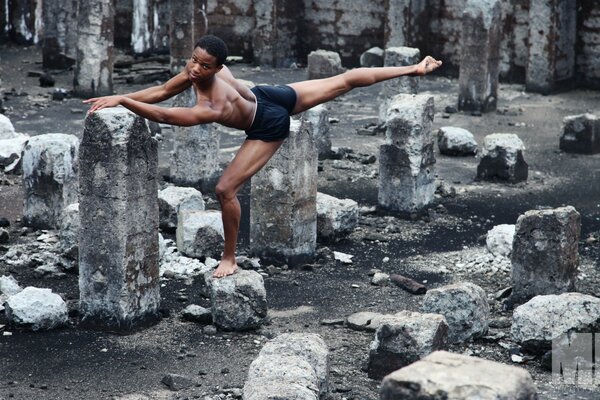 Hombre al aire libre haciendo yoga entre piedras