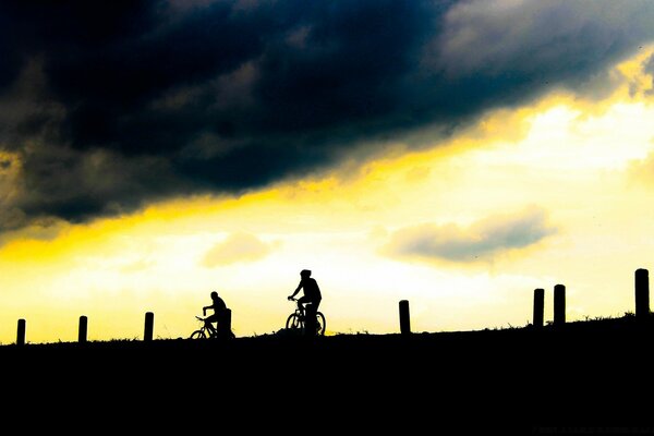 Ciclistas en medio del atardecer o el amanecer