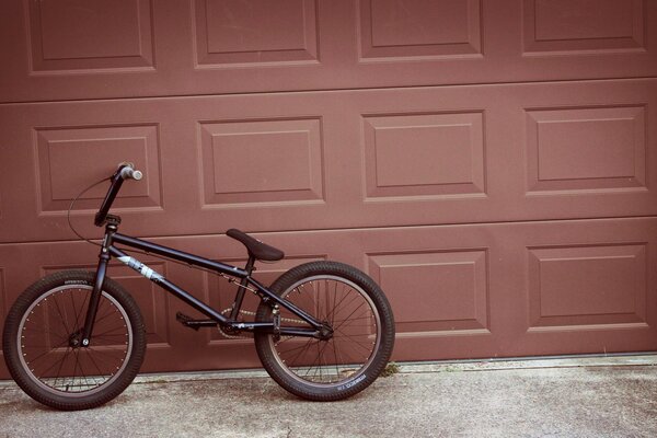 A bicycle next to a garage door that looks like a chocolate bar