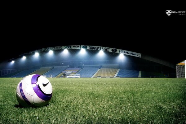 A soccer ball on an empty sports field. A ball on the grass