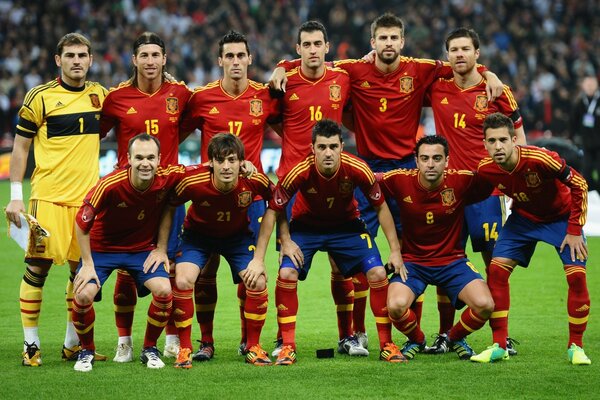 Un equipo de fútbol posa en un campo verde