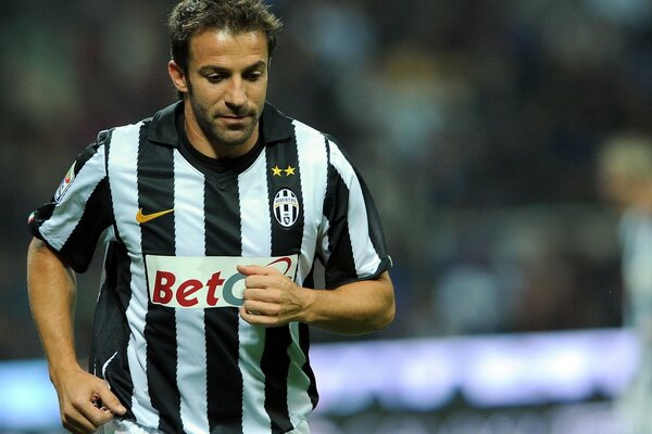 A football player running and with a thoughtful face in a striped T-shirt