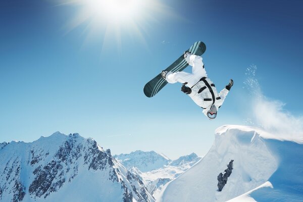 Der Trick eines Snowboarders in den Bergen