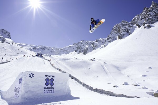 The snowboarder took off from the springboard. Extreme sports in the mountains