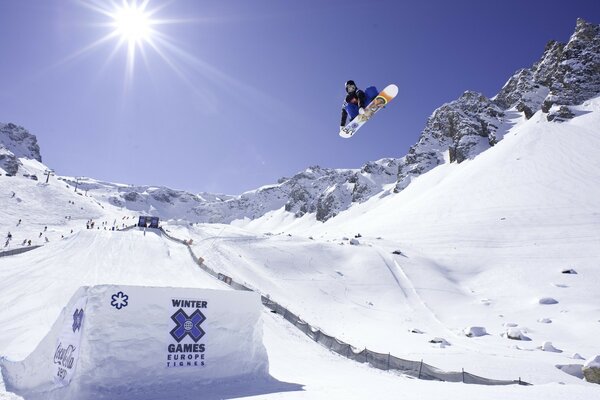 Snowboarder che salta oltre l ostacolo