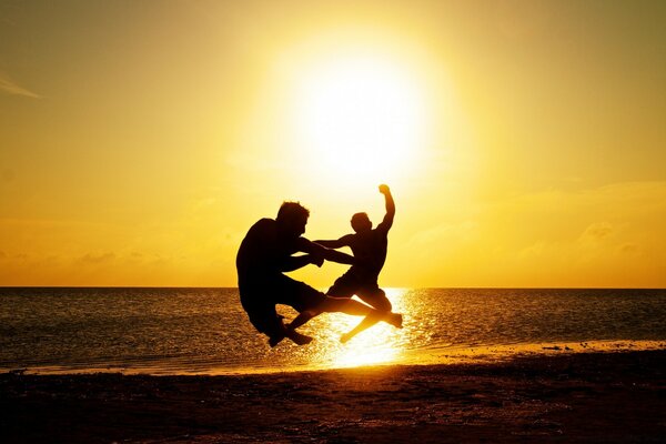 Two athletes jump on the beach