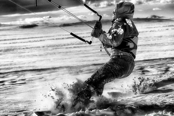 Schwarz-Weiß-Foto. Mann reitet auf einem Snowboard im Schnee