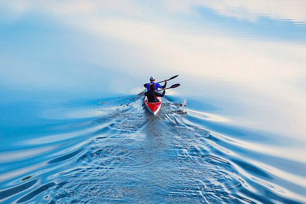 A man in a canoe swims away from the camera