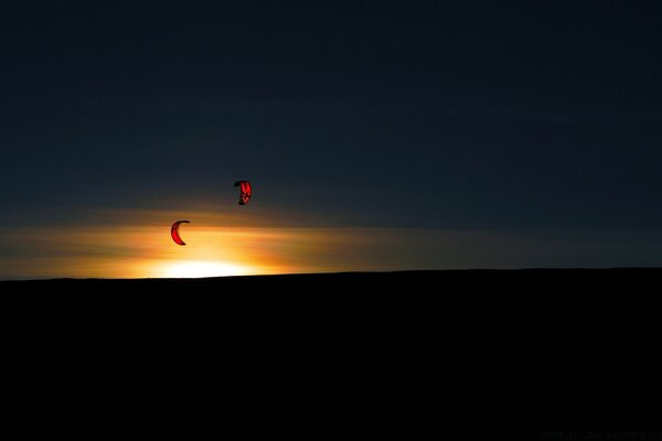 Paragliders high in the sky at sunset