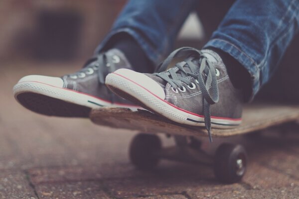 Füße in Schuhen auf einem Skateboard