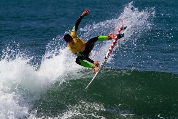 Surfeur rebondit sur une planche sur les vagues