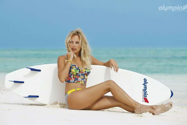 A girl with a surf on the beach against the background of sea waves