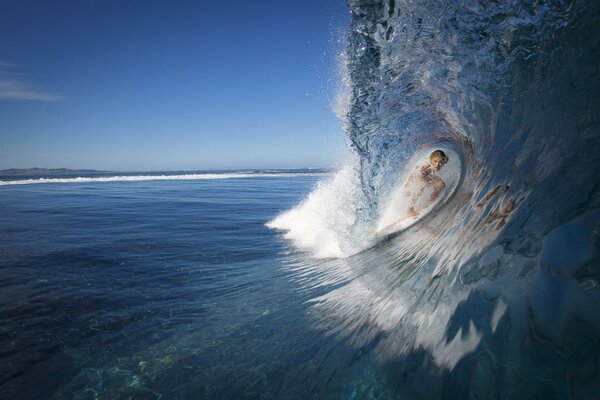 Фото серфингиста в огромной волне океана