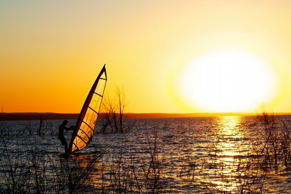 Surfingst w morzu o zachodzie słońca