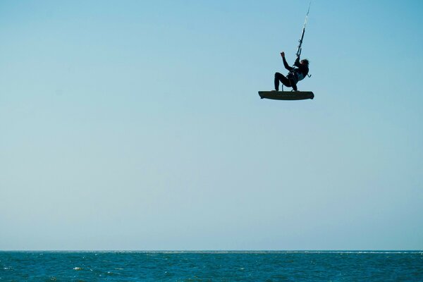 Against the background of the sky above the water, a man on a board