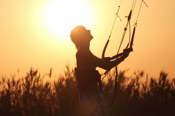 Silhouette of a parachutist with slings in the grass