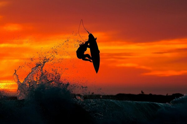 Silhouette eines Surfers bei abendlichem Sonnenuntergang