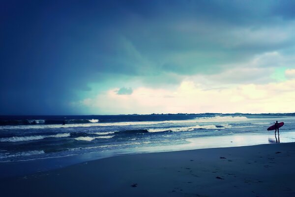 Surfer mit einem Brett in der Hand am Meer