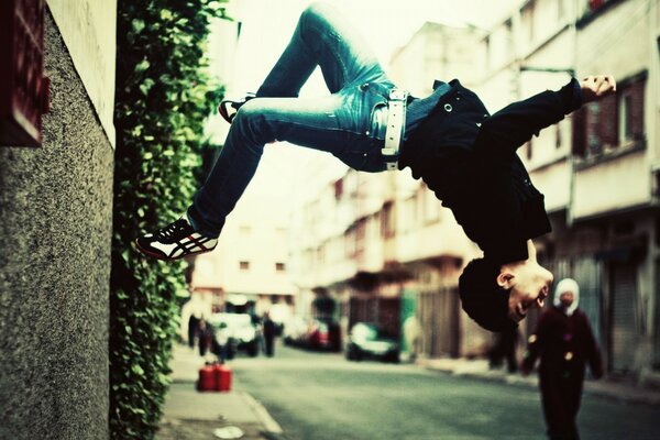 El chico hace un truco de parkour