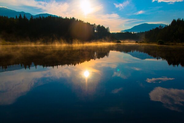 Dawn on a frosty lake in the middle of the forest