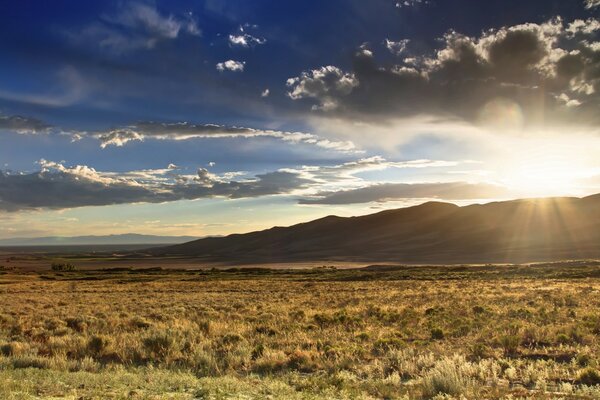 The sun s rays breaking through from behind the mountains