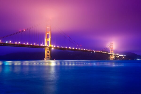 Puente nocturno iluminado por linternas