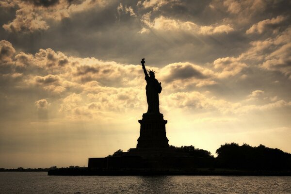 Freiheitsstatue bei Sonnenaufgang in den Gewässern des Hafens von New York