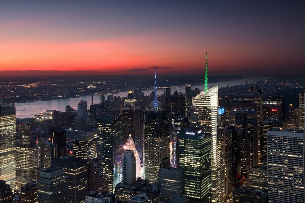 Ciudad nocturna y río al atardecer