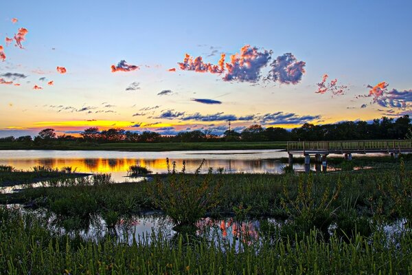 Pier on the shore of the lake at sunset