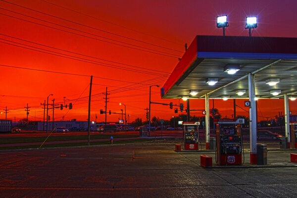 Verlassene Tankstelle vor dem Hintergrund eines purpurnen Sonnenuntergangs