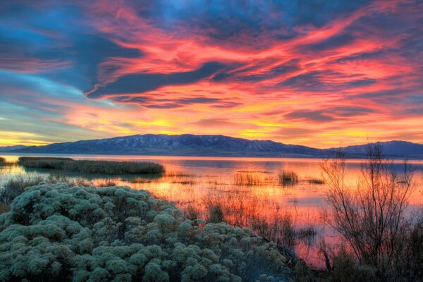 View of the mountains and the lake in the rays of dawn