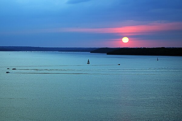 Sonnenuntergang auf dem Wasser, Boote segeln