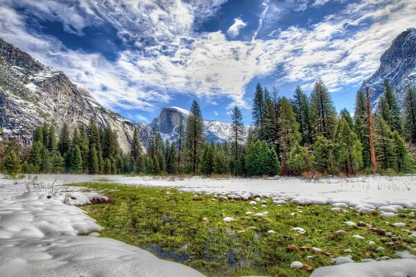 The first snow on the green near the mountains in America