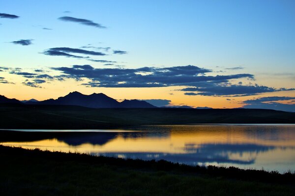 Paisaje con puesta de sol y cuerpo de agua por la noche