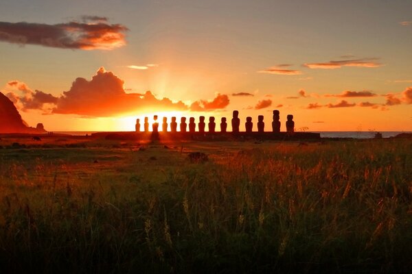 Sunrise landscape with statues in the field