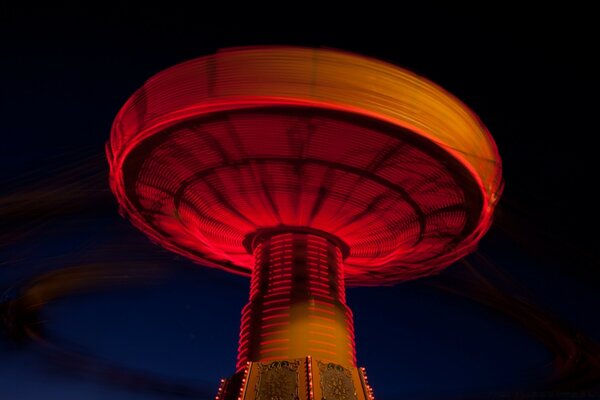 Something in the shape of a mushroom with a predominance of red on a black background