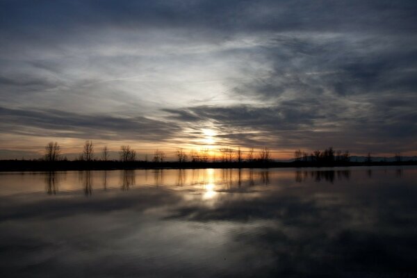 Bewölkter Sonnenaufgang über dem großen See