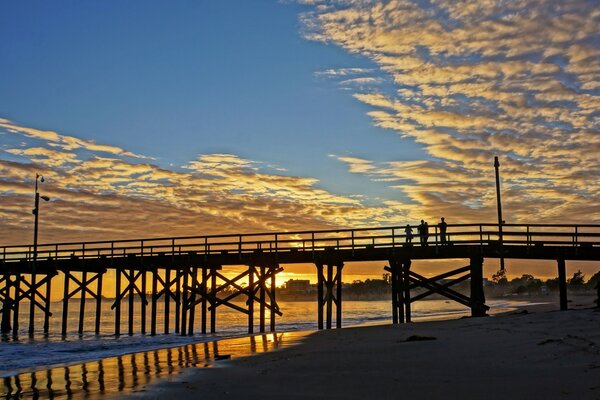 Coucher de soleil sur la mer sur fond de plage et pont