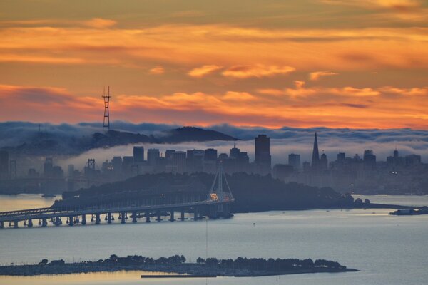 A city drowning in smog against the background of the dawn sky