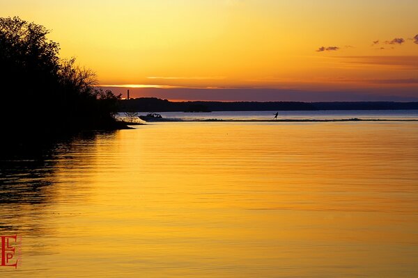 Reflejo de la puesta de sol en el agua en el fondo