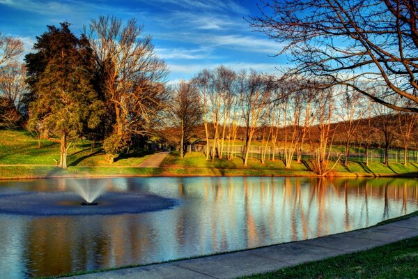 Herbstlandschaft mit Brunnen und Bäumen