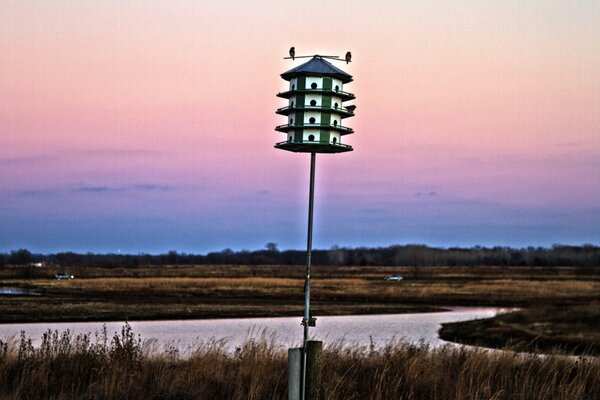 Birdhouse sullo sfondo di un tramonto cremisi