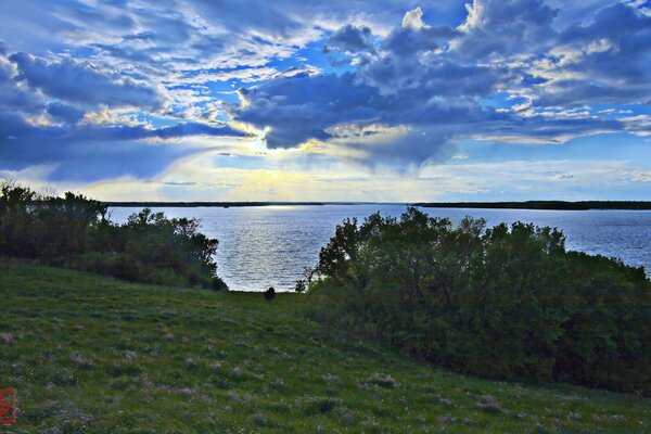 Coucher de soleil dans les nuages sur le lac vue de la colline