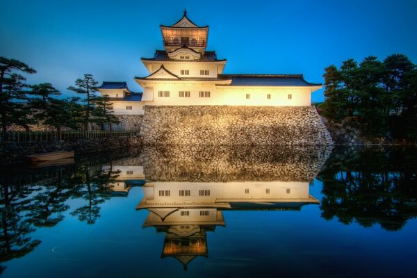 Asian-style building with night lighting on the background of water