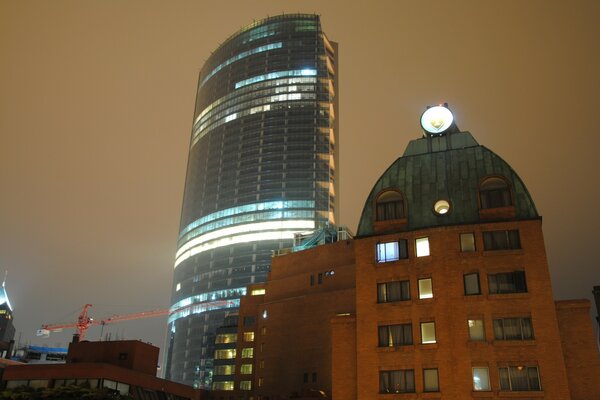 One skyscraper with smooth lines and a building with a non-standard roof