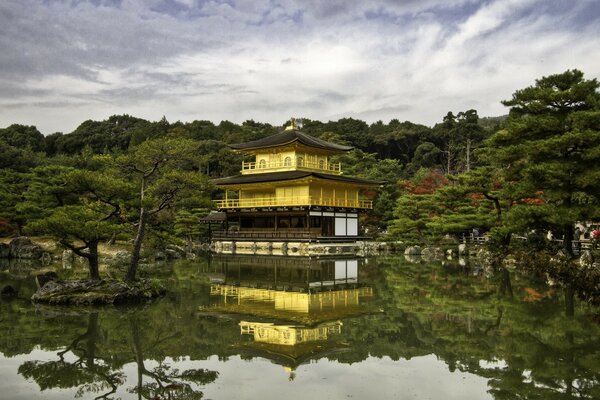 Pagoda junto al río contra el cielo nublado